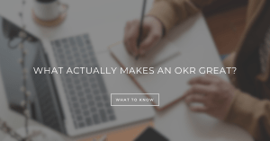 Two business professionals reviewing OKR document with clear metrics and newspaper headline-style objectives instead of a simple to-do list.